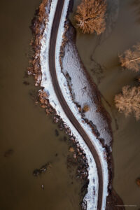 Een ondergesneeuwde dijk bij hoogwater in de Ooijpolder.