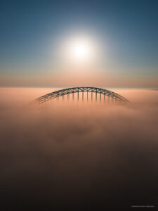 De Waalbrug hangt net boven de mistwolken in de vroege ochtend.